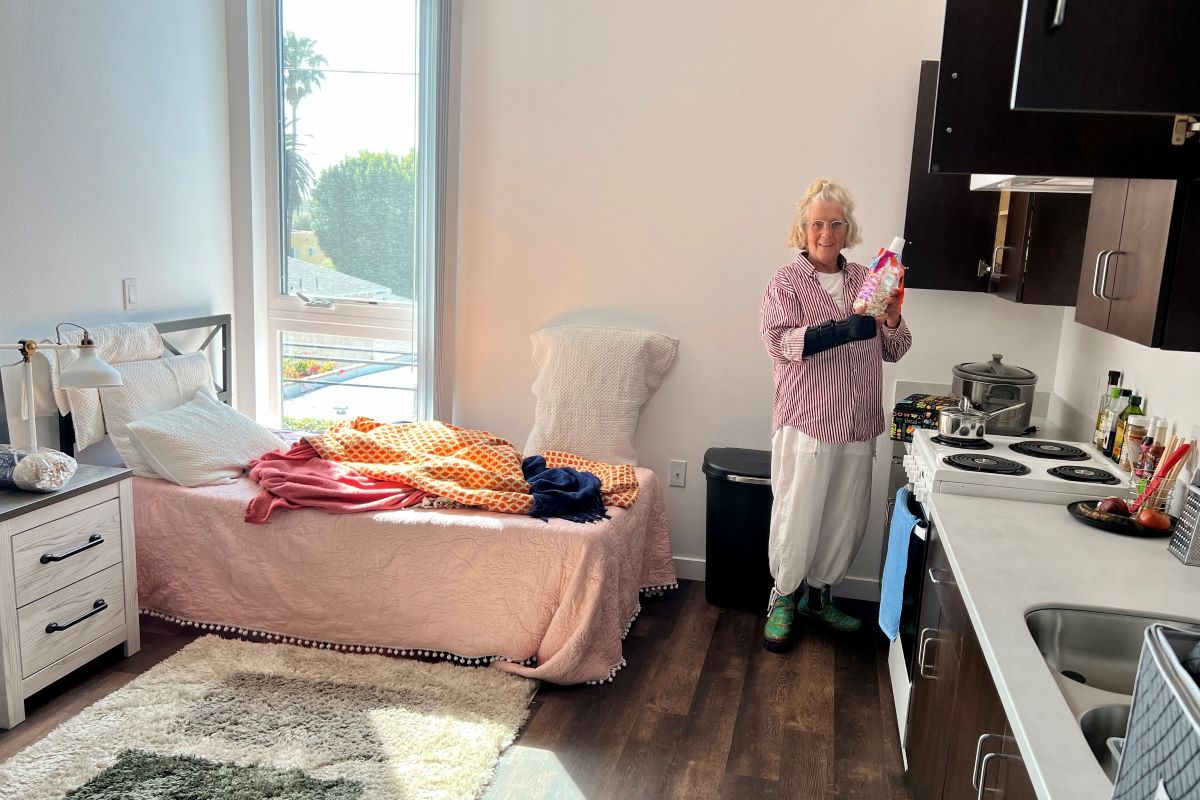 A woman who previously experienced homelessness moves into her new housing